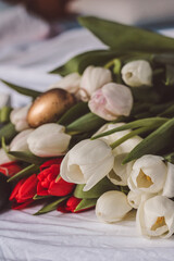 Sill life spring white and red tulips with golden and white easter eggs