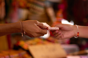 Goods for cash. Cropped shot of two hands exchanging cash at a store.