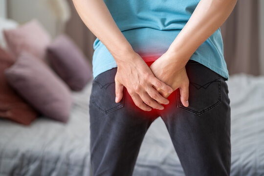 Hemorrhoidal pain, man suffering from hemorrhoids