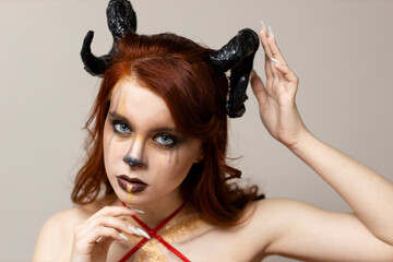 Beautiful young woman with makeup zodiac signs of Capricorn or Aries or Taurus. Girl with horns on...
