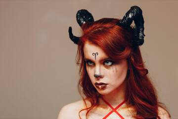 Beautiful young woman with makeup zodiac signs of Capricorn or Aries or Taurus. Girl with horns on head