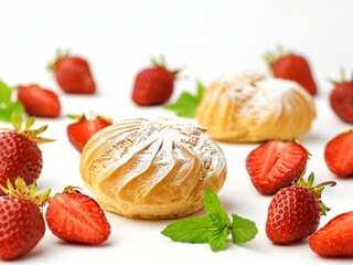 cakes eclair Profiteroles with strawberries mint on white background
