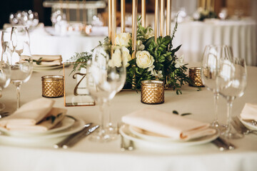 Wedding. Banquet. There are glasses, plates with napkins and cutlery on the festive table, the...