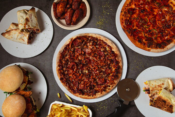 High angle view of table with various pizzas and burgers