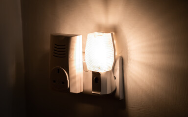 Close up of a night light plugged into a wall in a house
