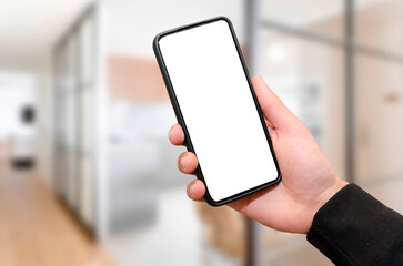 Man holding mobile phone with empty blank screen in hand at the office