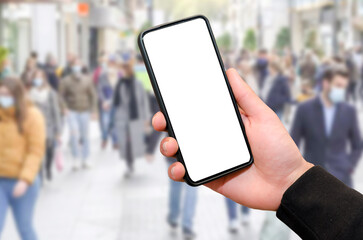 Man holding mobile phone with empty blank screen in hand outside