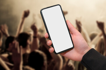 Man holding mobile phone with empty blank screen in hand in a concert