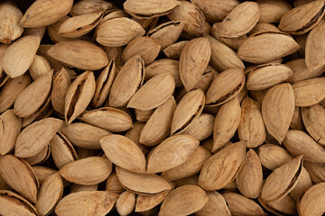 background of unpeeled almond nuts, close up