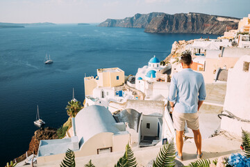 Junger Mann in hellblauen Hemd blickt auf die Caldera auf Santorin in Griechenland