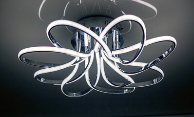 chrome led chandelier hanging on the ceiling in a modern interior.