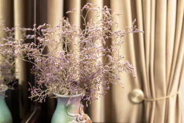 Still life. Vase with lilac flowers in a modern interior of a room in beige tones.