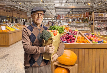 Elderly male customer in a grocery store with a paper bag