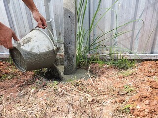 Dig a deep hole in the soil to pour mortar on the fence posts to strengthen the foundation.