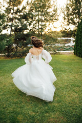 Beautiful wedding bride running in the garden