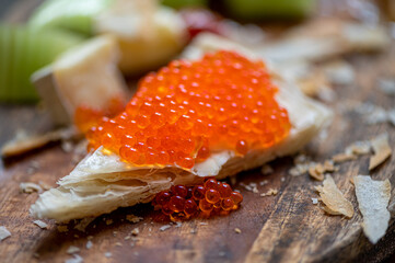 Bread with caviar in "Russian style" on wooden background.