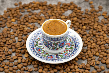 Turkish coffee in a classic coffee cup. Coffee beans background. close up