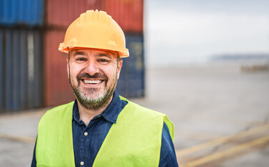 Worker senior man smiling on camera with industrial port on background - Focus on mouth