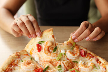 Female hands take a slice of pizza