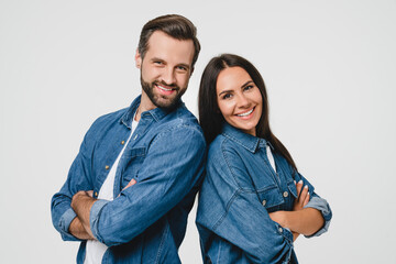 Fototapeta premium Closeup confident young caucasian couple spouses girlfriend and boyfriend looking at camera wearing denim jeans clothes isolated in white background. Love and relationship. Bonding