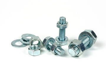 Several silver metal mounting bolts with nuts and washers on a white background. Close-up