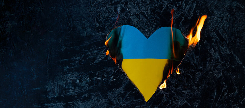 banner blue yellow heart like the flag of ukraine burns on a black background. Love Ukraine concept or war concept. - Powered by Adobe
