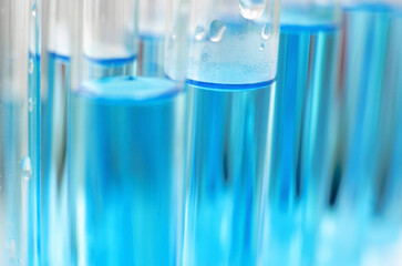 Laboratory test tubes with blue liquid close up, selective focus. Scientific laboratory research and experiments.