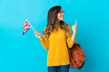 Young hispanic woman holding an United Kingdom flag isolated on blue background pointing up a great idea