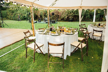 Wedding. Banquet. The chairs and round table for guests, served with cutlery.
