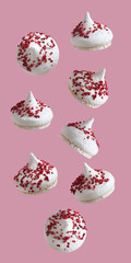 Meringue cakes with dried raspberries on a light pink background. Closeup.
