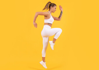 Fototapeta na wymiar fitness coach woman jumping on yellow background