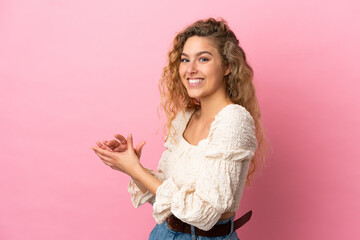 Obraz na płótnie Canvas Young blonde woman isolated on pink background applauding