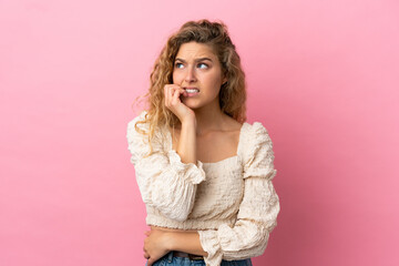 Fototapeta premium Young blonde woman isolated on pink background is a little bit nervous