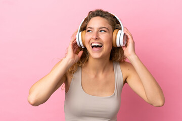 Fototapeta premium Young blonde woman isolated on pink background listening music and singing