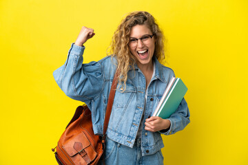 Young student caucasian woman isolated on yellow background doing strong gesture - obrazy, fototapety, plakaty