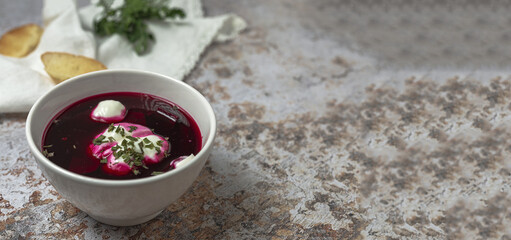 Traditional Ukrainian and Russian national red borscht soup en bol with sour cream and herbs