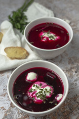Traditional Ukrainian and Russian national red borscht soup en bol with sour cream and herbs