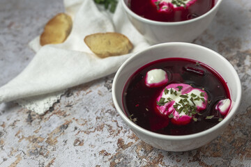 Traditional Ukrainian and Russian national red borscht soup en bol with sour cream and herbs