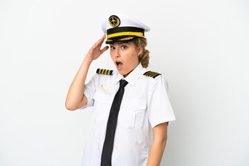 Airplane blonde woman pilot isolated on white background doing surprise gesture while looking to the side