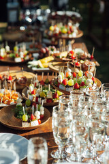 Table of various snacks, sandwiches, strawberries and champagne glasses. Buffet for wedding guests