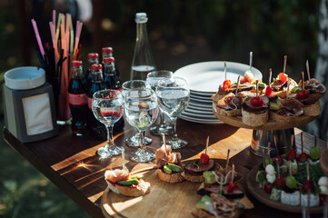 Table of various snacks, sandwiches, strawberries and champagne glasses. Buffet for wedding guests