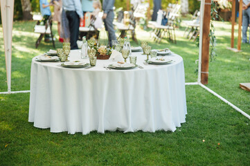 Wedding. Banquet. The chairs and round table for guests, served with cutlery.