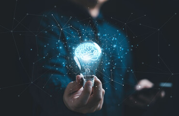 Businessman hand holding lightbulb with glowing virtual brain and  connection line to creative smart thinking for inspiration and innovation with network concept.