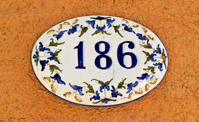 Street sign number 186 on a orange wall