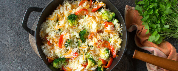 pan with rice with broccoli and bell pepper on the table