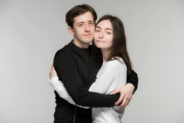 boy and girl hugging on a light gray background