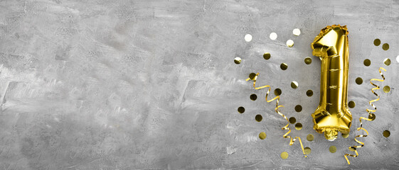 Yellow foil balloon number, number one on a concrete background. Birthday card with lettering 1....