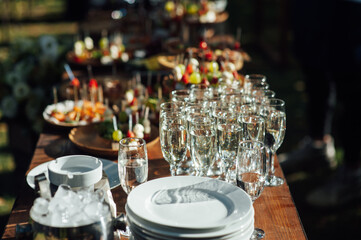 Table of various snacks, sandwiches, strawberries and champagne glasses. Buffet for wedding guests