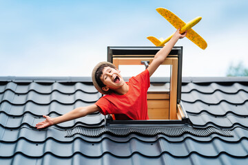 Little happy boy playing with toy airplane in an open skylight. Happy summer vacation. Hello summer...