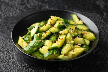 Smashed cucumber spicy Asian style salad with soy sauce dressing, chilli flakes, garlic and sesame seeds